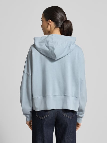 Frauenmodel trägt Relaxed Fit Hoodie aus reiner Baumwolle von Marc O'Polo, Optik: Unifarben, Passform: Relaxed-Fit, Label-Print, überschnittene Schultern, Kapuze, Langarm, Ärmelabschluss: Gerippt, Rumpfabschluss: Gerippt, Materialverarbeitung: Sweat, Ganzkörperansicht Rückansicht.