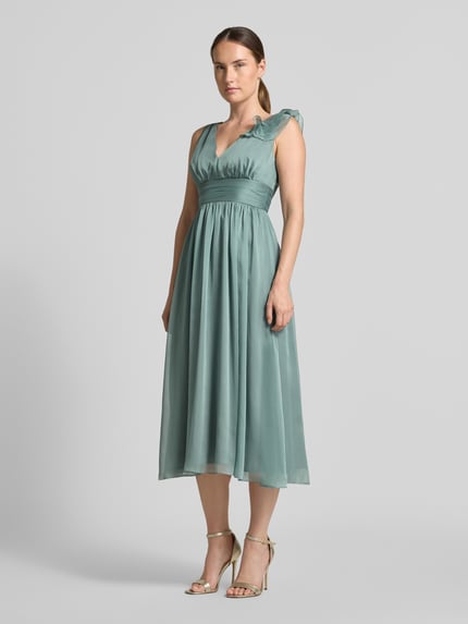 Frauenmodel trägt Cocktailkleid mit V-Ausschnitt von Swing in Taillierter Passform mit Raffungen, Taillenband, Volants, Reißverschluss hinten, Midikleid in sanftem Grün, glatte Textur, Ganzkörperansicht von vorne.