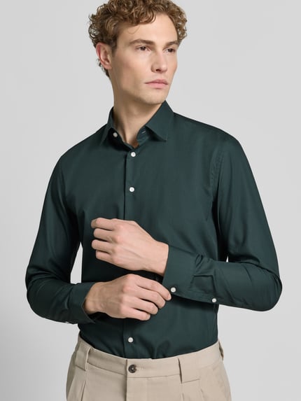 Männermodel trägt Slim Fit Business-Hemd mit Kentkragen von Jake*s in Dunkelgrün, Reine Baumwolle, Knopfleiste, Nahaufnahme Oberkörper, Rückenlänge bei Größe 39/40: 79 cm, Schulterbreite: 45 cm, Ärmellänge: 67 cm.