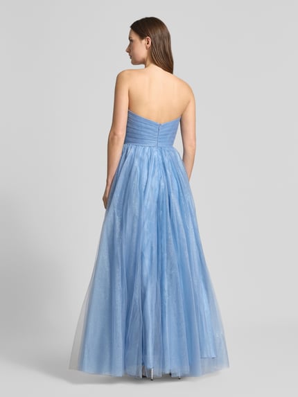 Frauenmodel trägt Regular Fit Abendkleid mit Glitzer-Mesh von Mascara in Hellblau mit A-Linie und Gehschlitz, schulterfrei, Ganzkörperansicht Rückansicht.