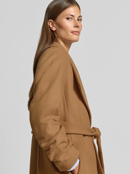 Kobiece model nosi Mantel mit Woll-Anteil von Christian Berg Woman Selection, kolor brązowy, Mieszanka materiałów z dodatkiem wełny, tasiemka w talii, szalowy kołnierz, taliowany krój, Długość tyłu w rozmiarze 36: 113 cm, Szerokość ramion w rozmiarze 36: 37 cm, Szerokość klatki piersiowej w rozmiarze 36: 41 cm, Długość rękawów w rozmiarze 36: 67 cm, zbliżenie na górną część ciała