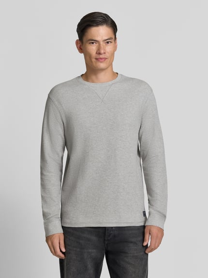 Mannenmodel draagt Regular Fit Longsleeve met Wafelstructuur van Scotch & Soda, puur katoen, ronde hals, labelpatch, ruglengte maat M 65 cm. Ganzkörperansicht von vorne.