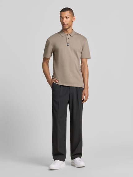 Męski model nosi Regular Fit Poloshirt aus reiner Baumwolle Modell 'DEABONO' od HUGO w jednolitym kolorze, krój regular fit, krótki rękaw, logo patch, polówkowy kołnierz, dekolt w serek, zapięcie na dwa guziki, materiał jersey, bawełna; widok całej sylwetki z przodu.