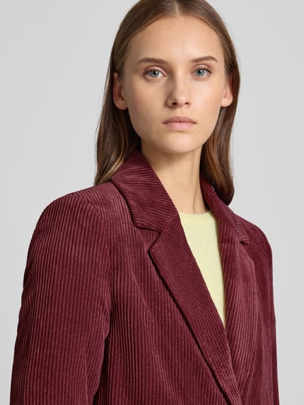 Frauenmodel trägt Regular Fit Mantel mit Reverskragen Modell 'ASTRID' von ONLY, Cordmaterial mit feiner Rippenstruktur, unifarben, Nahaufnahme Oberkörper.