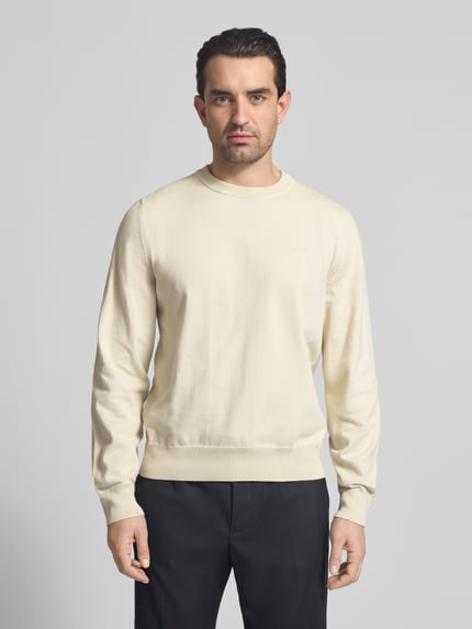 Männermodel trägt Regular Fit Strickpullover aus reiner Baumwolle Modell 'UPCAS' von BOSS, Optik: Unifarben, Ganzkörperansicht von vorne.
