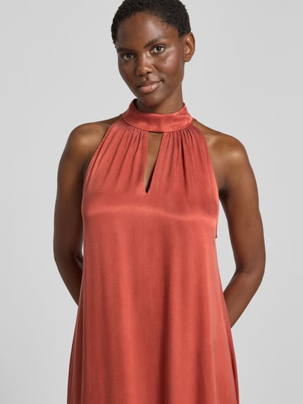 Frauenmodel trägt Midikleid aus Viskose-Mix mit Neckholder von Jake*s Collection in Rostrot, glatte Textur, Nahaufnahme Oberkörper.