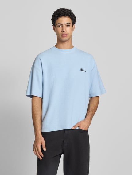 Mannermodel draagt lichtblauw T-shirt mit Rundhalsausschnitt und Label-Stitching van REVIEW, katoenmix, relaxed fit, ruglengte maat M 64 cm, ganzkörperansicht van voren.