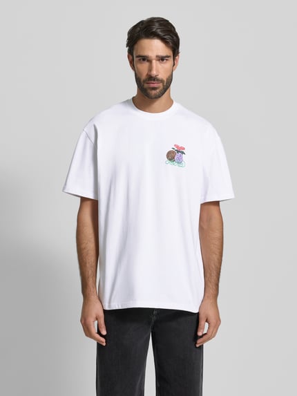 Männermodel draagt T-shirt met labelprint en ronde hals van Les Deux, puur katoen, relaxed fit, model 'Cole Table', ruglengte maat M 71 cm, Ganzkörperansicht van voren.