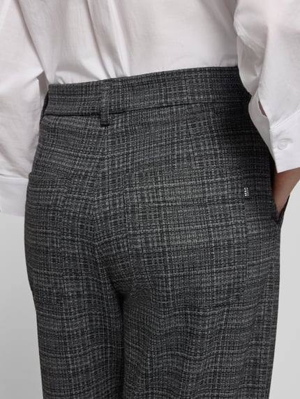 Frauenmodel trägt Regular Fit Hose mit Bundfalten Tilda Jump in von MAC mit grauem Glencheck Allover-Muster, Detailaufnahme Rückansicht.