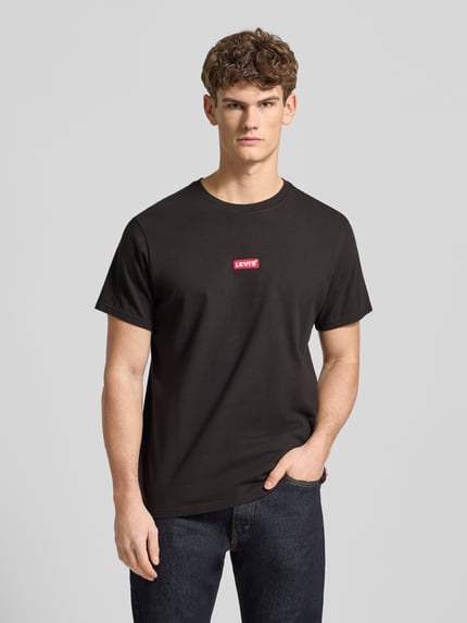 Männermodel trägt T-Shirt mit Label-Detail von Levi's®, schwarz, reine Baumwolle, relaxed Fit, Nahaufnahme Oberkörper.