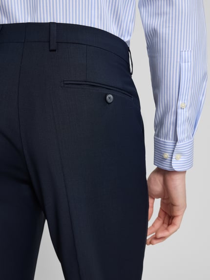 Männermodel trägt Slim Fit Anzug mit 2-Knopf-Sakko Modell 'Grant' van Pierre Cardin in donkerblauw, materiaal-mix met scheerwol, detailopname rugzijde.