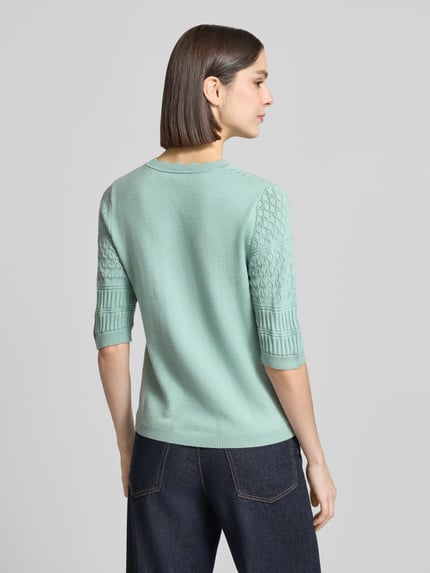 Vrouwenmodel draagt gebreide pullover met viscosemix, regular fit, model 'MILOS' van Vila, ronde hals, 1/2-mouwen, ruglengte 52 cm, mouwlengte 32 cm, lichtgroen, textuur met patroon op de mouwen, volledige achteraanzicht.