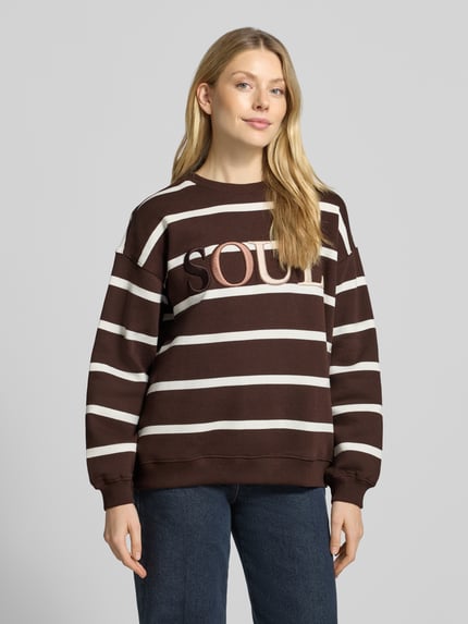 Modelka nosi Oversized Sweatshirt aus Baumwoll-Mix mit Statement-Stickerei von Smith and Soul, brązowy w białe paski, Wyhaftowany napis, prążkowane wykończenia, okrągły dekolt, mieszanka bawełny, Krój oversized, przód na całej sylwetce.