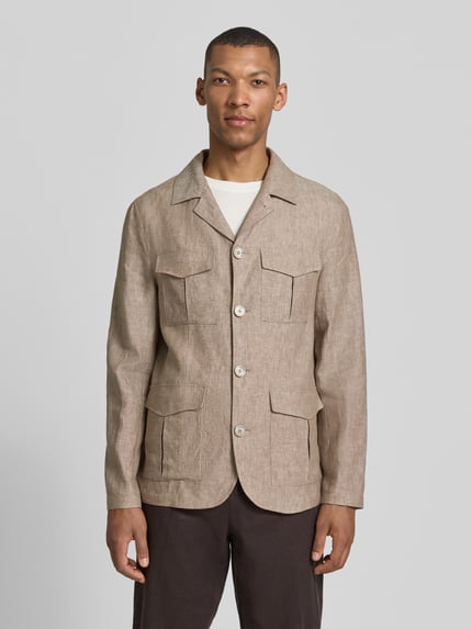 Mannenmodel draagt Hemdjacke aus Leinen mit Pattentaschen van Zuitable, lichtbruin linnen, regular fit, reverskraag, knoopsluiting, vier klepzakken, achterkantlengte maat M 71 cm, frontale opname van het volledige lichaam.