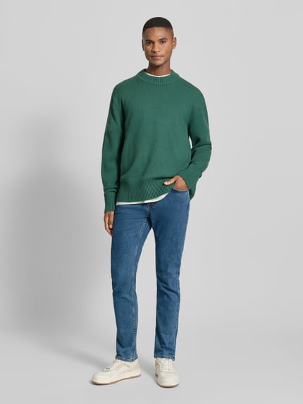 Mannenmodel draagt Slim Fit Jeans aus Baumwoll-Mix Modell 'DELAWARE' van BOSS Orange, 5-pocket denim in melange-look, geheellichaamsvooraanzicht.