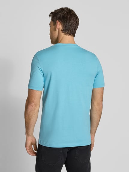 Männermodel trägt Regular Fit T-Shirt aus reiner Baumwolle von s.Oliver RED LABEL in Unifarben, Jersey-Struktur, Ganzkörperansicht Rückansicht.