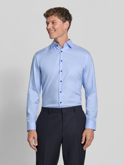 Männermodel trägt Regular Fit Businesshemd mit kontrastierendem Innenkragen von Seidensticker, hellblau, feines Webmuster, Ganzkörperansicht von vorne.