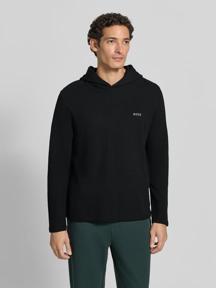 Männermodel trägt schwarzen Relaxed Fit Sweatshirt aus Baumwoll-Mix Modell 'Waffle LS' von BOSS, Ganzkörperansicht von vorne, Herren Hoodie.