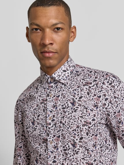 Männermodel trägt Regular Fit Businesshemd mit Kentkragen von OLYMP, florales Allover-Muster, mehrfarbig, Nahaufnahme Oberkörper.