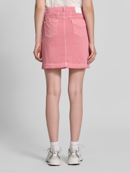 Frauenmodel trägt Straight Fit Minirock in Denim-Optik von Marc Cain, rosa Farbton, Baumwoll-Mix, Eingriff- und Gesäßtaschen, Ganzkörperansicht Rückansicht.
