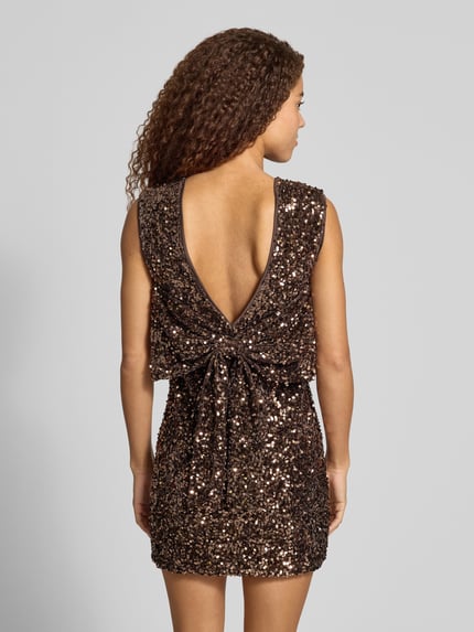 Frauenmodel trägt Paillettenkleid mit Schleifendetail hinten von ONLY, glänzend, strukturierte Mini-Länge, ärmellos, Ganzkörperansicht Rückansicht.