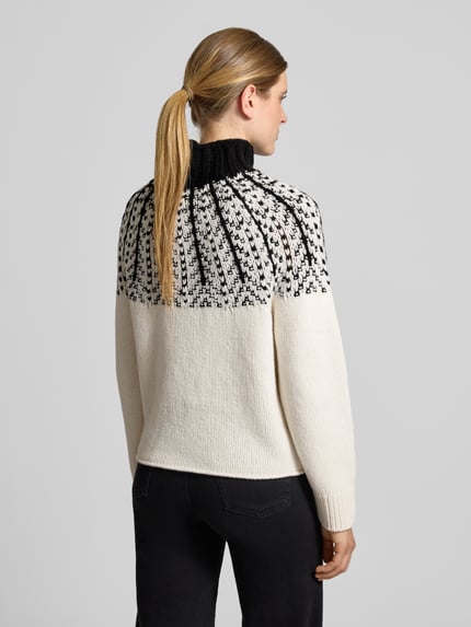Modelka nosi Strickpullover aus Wolle mit Stehkragen von Closed, czarno-biały, krój straight fit, gruby splot, rękawy z prążkowanymi ściągaczami, długość tyłu 56 cm, długość rękawa 67 cm, widok całej sylwetki od tyłu.