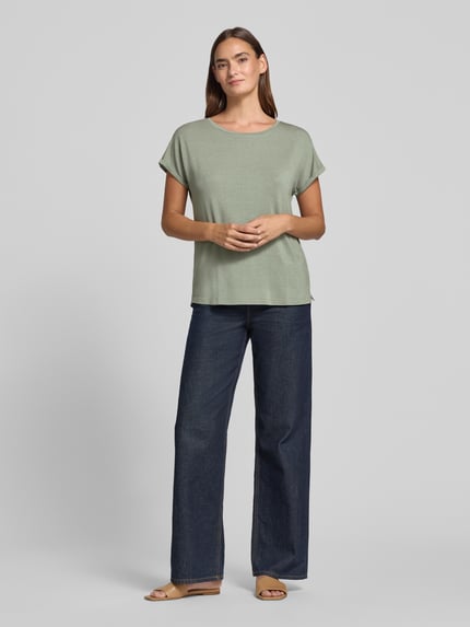 Modelka nosi Relaxed Fit T-Shirt aus Viskose-Mix von Christian Berg Woman, jasnozielony, z okrągłym dekoltem, połyskująca tekstura, widok całej sylwetki z przodu.