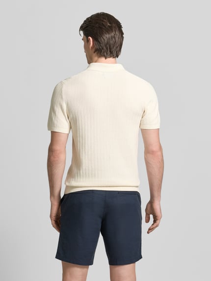 Mannelijk model draagt poloshirt met kort ritssluiting en polokraag van MCNEAL, biologisch katoen, body fit, ribboorden, ruglengte maat M 69 cm, mouwlengte maat M 25 cm, crèmekleur, donkerblauwe short, structuur, volledige lichaamsaanzicht rugaanzicht.