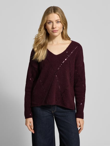 Frauenmodel trägt Strickpullover mit Paillettenbesatz von Milano Italy in dunklem Lila mit lockerem Schnitt und U-Ausschnitt, Ganzkörperansicht von vorne. Material-Mix mit Alpaka-Anteil, Rückenlänge 57 cm, Ärmellänge 64 cm.