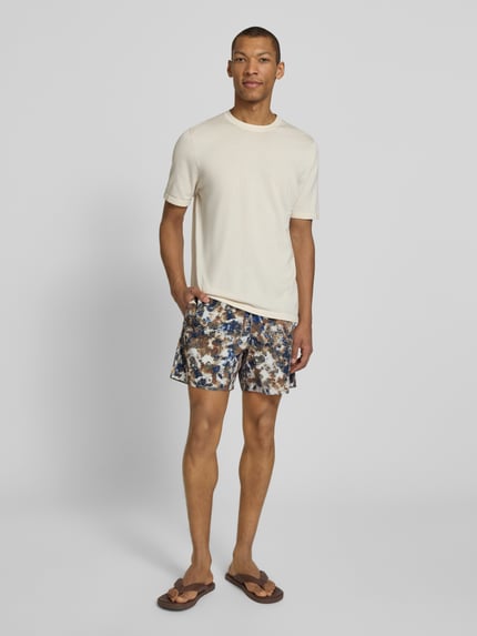 Männermodel trägt Shorts im Allover-Look mit elastischem Bund von ARMANI EXCHANGE, bunter Print, Regular Fit, Ganzkörperansicht von vorne.