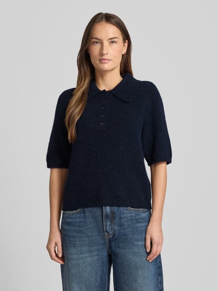 Frauenmodel trägt Regular Fit T-Shirt mit Alpaka-Lanawoll-Anteil Modell 'Alpha' von Gestuz, Polo-Kragen, Halbarm, Dunkelblau, Strick-Optik, Ganzkörperansicht von vorne.