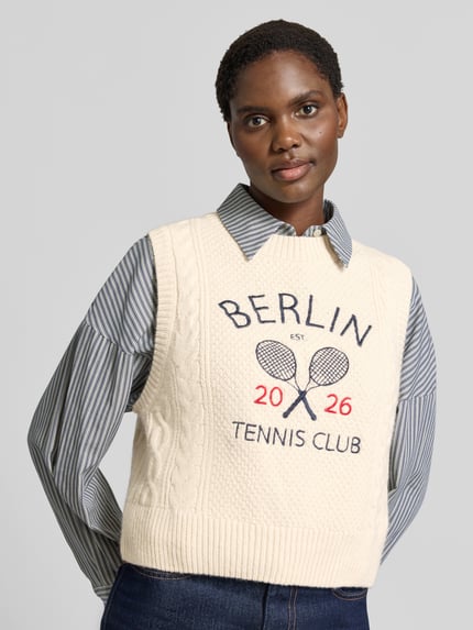 Frauenmodel trägt Pullunder aus Schurwoll-Mix von Lanius, cremefarben, Strick-Optik mit Statement-Stitching, gerippter Bund, Regular Fit, Ganzkörperansicht von vorne.