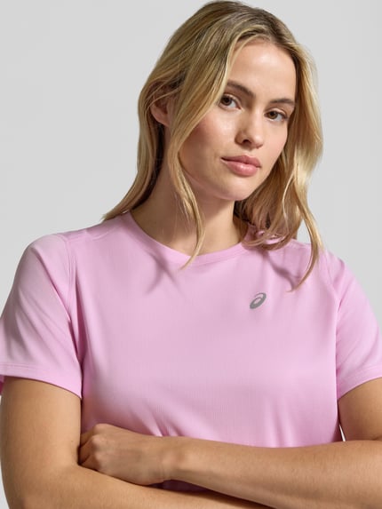 Modelka nosi Damski t-shirt Regular Fit T-Shirt mit Logo-Print od Asics w jasnoróżowym kolorze, Nadruk z logo, okrągły dekolt, krótki rękaw, długość tyłu w rozmiarze S: 63 cm, zbliżenie górnej części ciała.