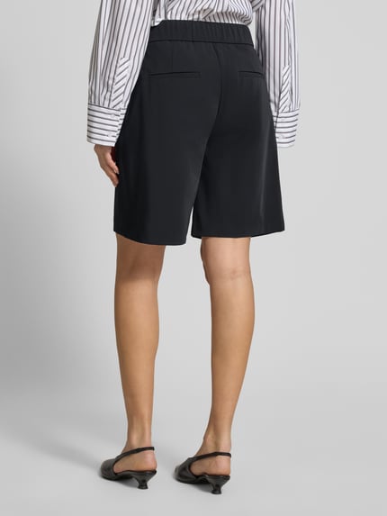 Frauenmodel trägt Schlupfbermuda Techno Cotton Superstretch von Raffaello Rossi, Regular-Fit, Elastischer Bund, Gesäßtaschen, Modell 'ISKA', Schwarz, Ganzkörperansicht Rückansicht, Bundweite bei Größe 36: 39 cm, Innenbeinlänge bei Größe 36: 24 cm.