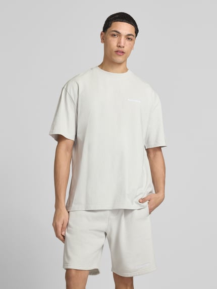 Männermodel trägt Oversized T-Shirt mit Logo-Stitching von Pegador, Herren T-Shirt aus Reine Baumwolle, Oversized-Fit, Rundhalsausschnitt, Rückenlänge 73 cm, Ganzkörperansicht von vorne.