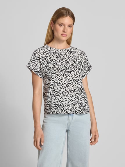 Frauenmodel trägt Blusenshirt im Allover-Look Modell 'JOSA' von Vila, schwarz-weiß gepunktet, Regular Fit, Rundhalsausschnitt, Ganzkörperansicht von vorne.