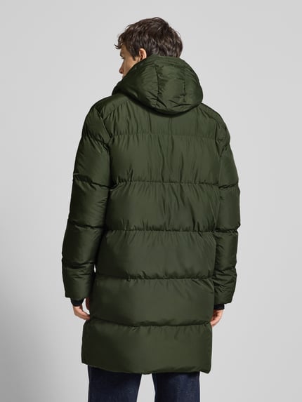 Mannenmodel draagt Steppmantel met Kapuze und Zweiwege-Reißverschluss van Superdry in recht model, olijfgroen, gladde textuur, volledige lichaamsopname achteraan. Afmetingen maat M: ruglengte 99 cm, schouderbreedte 49 cm, borstwijdte 62 cm, mouwlengte 71 cm.