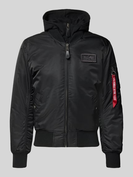 Produktfoto, Jacke mit Reißverschlusstasche am Ärmel von Alpha Industries in Schwarz, glatte Oberfläche, gerippte Abschlüsse, Label-Details