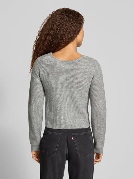 Vrouwenmodel draagt Regular fit pullover met asymmetrisch wikkeldetail van PIECES in grijs met ribstructuur, rugaanzicht.