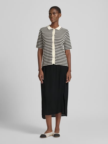 Vrouwenmodel draagt midirok uit zuiver viscose met elastische band model 'MARRAKECH' van ICHI, zwarte A-lijn, voorkant vollichaamsaanzicht.