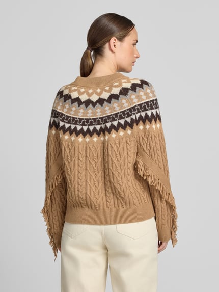 Frauenmodel trägt Regular Fit Strickpullover mit Lanawoll-Anteil von Christian Berg Woman in Beige mit Zopfmuster und Fransen, Ganzkörperansicht Rückansicht. Material-Mix, gerippte Abschlüsse, Rundhalsausschnitt, langärmliges Design.
