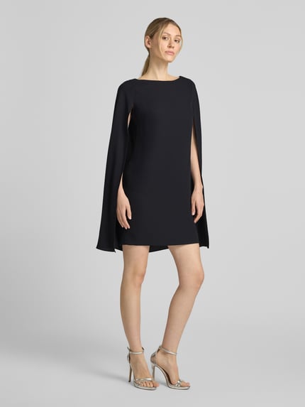 Frauenmodel trägt A-Linien Cocktailkleid mit Cape von Lauren Ralph Lauren in Schwarz, glatter Stoff, Ganzkörperansicht von vorne. Damen Cocktailkleid.