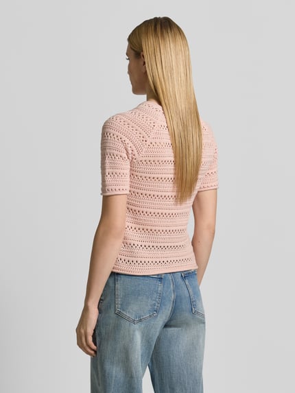 Frauenmodel trägt Strickshirt mit Rundhalsausschnitt von Jake*s Casual aus Reine Baumwolle in zartem Rosa, strukturierte Oberfläche, Regular-Fit, Rollsaum, Rückenlänge 52 cm, Ärmellänge 26 cm, Ganzkörperansicht Rückansicht.