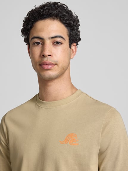 Männermodel trägt T-Shirt mit Motiv-Print Modell 'SUN SURF' von Blend aus reiner Baumwolle in Beige, Nahaufnahme Oberkörper.