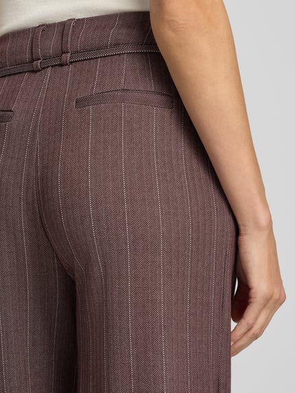 Männermodel trägt spodnie z mieszanki wiskozy z dodatkiem streczu, wzór na całej powierzchni, zakładki w pasie, wiązany pasek, Model 'KATE PINELLE' od ICHI, Szerokość w rozmiarze S: 37 cm, Długość wewnętrzna nogawki: 78 cm, detaliczne zbliżenie na tył