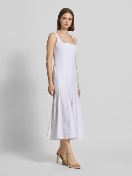 Frauenmodel trägt Cocktailkleid mit Karree-Ausschnitt Modell 'LOLITA' von Bardot aus weißem Baumwoll-Mix mit Stretch-Anteil, körpernaher-Schnitt, Midikleid, breite Träger, rückseitiger Haken-Reißverschluss, glatte Textur, Ganzkörperansicht von vorne.