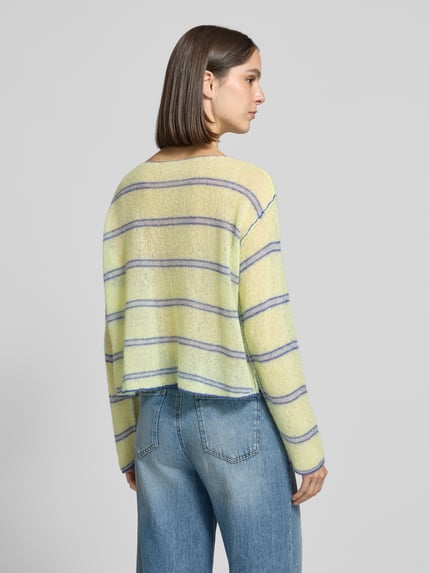 Frauenmodel trägt Relaxed Fit Strickpullover aus Lyocell-Mix Modell 'BODYROW' von American Vintage mit Streifen in Gelb und Blau, Damen Strickpullover, lockerer Schnitt, U-Boot-Ausschnitt, Langarm, überschnittene Schultern, Ganzkörperansicht Rückansicht.