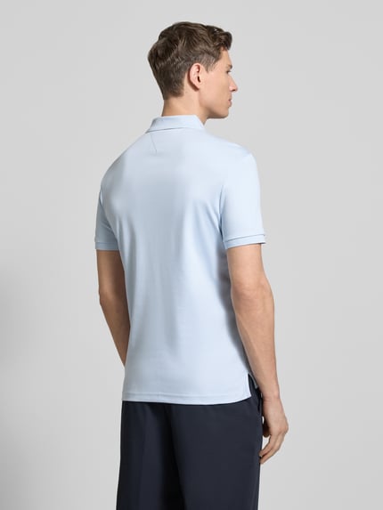 Männermodel trägt lichtblauw Regular fit Poloshirt aus reiner katoen Model 'LIQUID COTTON' von Tommy Hilfiger, mêlee look, gestikt logo, polokraag, korte mouw, geribde mouwboord, rompzoom met zijsplitten, Ganzkörperansicht Rückansicht.