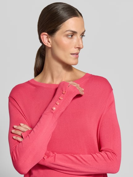 Frauenmodel trägt Pullover aus Viskosemix mit Knopfdetails am Ärmel von TOM TAILOR in Pink, Feinstrickoptik, Nahaufnahme Oberkörper.