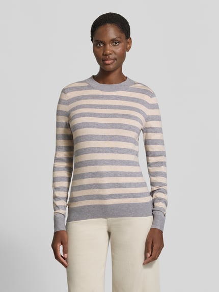 Frauenmodel trägt Strickpullover mit Rundhalsausschnitt von Christian Berg Woman im Viskose-Mix mit beige-grauen Streifen, Ganzkörperansicht von vorne.